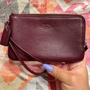 Used Coach dark burgundy/wine colored wristlet with two zippers